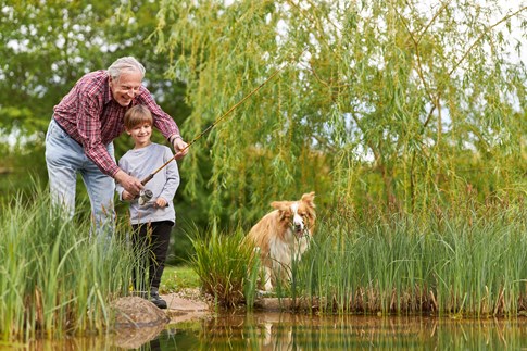 Kind, Hund und Herrchen Angeln gemeinsam am See