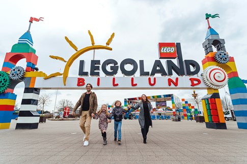 Eine glückliche Famiklie vor dem Eingang vom Legoland