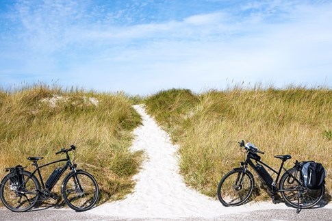 Zwei E-Bikes vor den Dünen auf Sylt